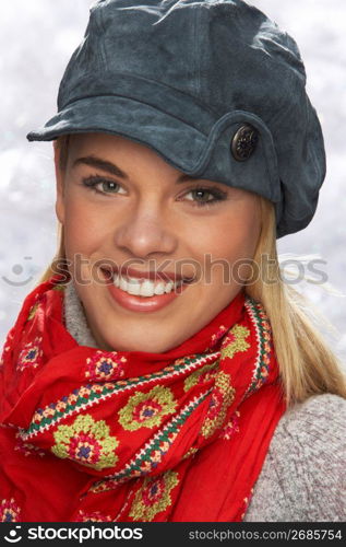 Fashionable Teenage Girl Wearing Cap And Knitwear In Studio In Front Of Christmas Tree