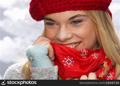Fashionable Teenage Girl Wearing Cap And Knitwear In Studio In Front Of Christmas Tree