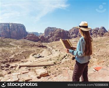 Fashionable woman, exploring the sights of the ancient, fabulous city of Petra in Jordan. Colorful photos. Concept of leisure, vacation and travel. Woman exploring the sights city of Petra