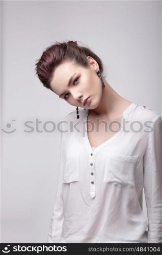 Fashionable woman in a white blouse looks into the camera.