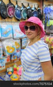 Fashionable woman in pink hat and sunglasses enjoying shopping. Fashion woman wearing summer hat and sunglasses. Modern woman in shop. Attractive girl in stylish hat. Fashionable woman in pink hat and sunglasses enjoying shopping. Attractive girl