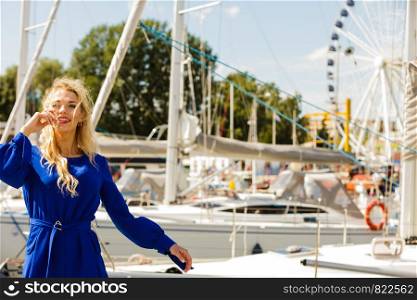 Fashionable woman wearing blue navy shirt perfect for summer. Fashion model outdoor photo shoot against ferris wheel.. Fashion model against ferris wheel