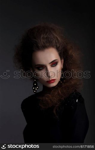 Fashionable woman with high hair, a photo session in the studio. Red lips, professional makeup.