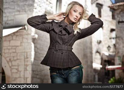 Fasion style portrait of a blond woman wearing an autumn coat