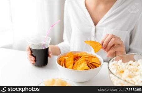fast food and people concept - close up of woman eating corn nachos and drinking cola. close up of woman eating corn nachos with cola