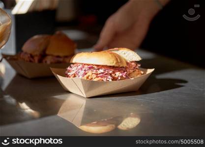 fast food and unhealthy eating concept - hamburger in disposable paper plate on table. hamburger in disposable paper plate on table