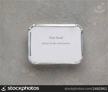 fast food in a foil box on a gray rough background. food for businessman and busy people. fast food set