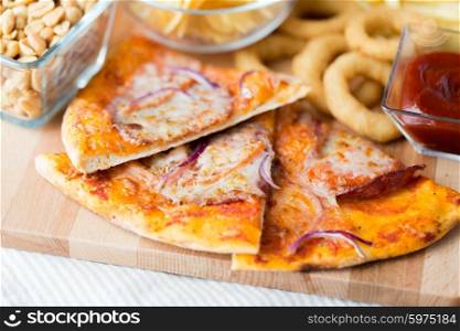 fast food, italian kitchen and eating concept - close up of pizza and other snacks on wooden table