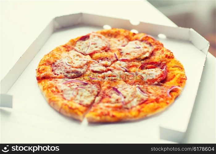 fast food, italian kitchen and eating concept - close up of pizza in paper box on table