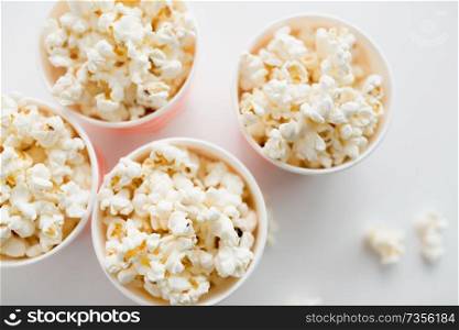 fast food, junk-food and unhealthy eating concept - close up of popcorn in disposable paper cups from top. close up of popcorn in disposable paper cups