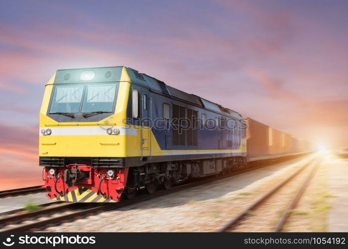 Fast freight blue train at sunset with motion blur