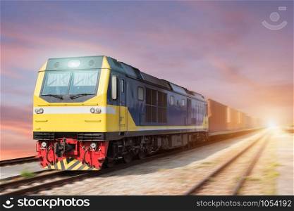 Fast freight blue train at sunset with motion blur