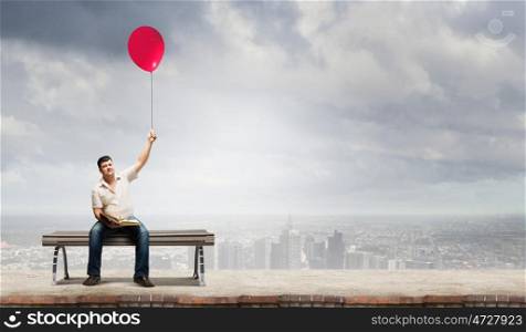 Fat man. Fat man sitting on bench with book and balloon in hand
