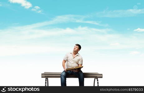 Fat man. Fat man sitting on bench with book and looking away