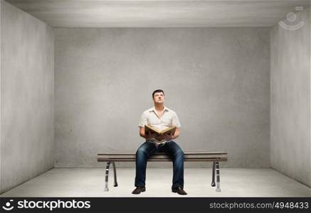 Fat man. Fat man sitting on bench with book and looking away