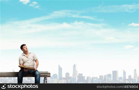 Fat man. Fat man sitting on bench with book and looking away