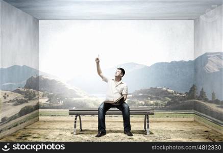 Fat man. Fat man sitting on bench with book and pointing with finger