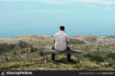 Fat man. Fat man sitting on bench with his back and looking away