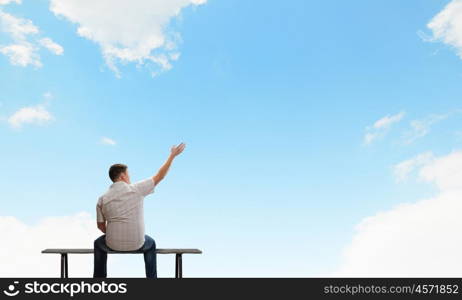 Fat man. Fat man sitting on bench with his back and pointing away