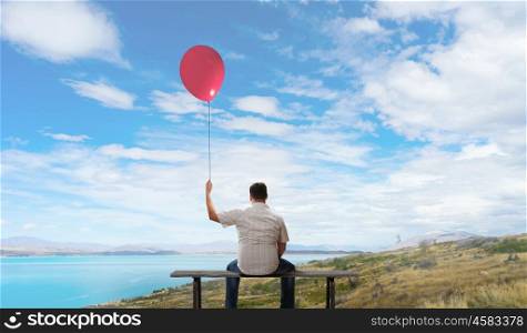 Fat man. Fat man sitting on bench with his back with balloon in hand