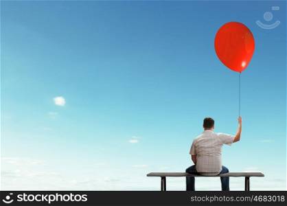 Fat man. Fat man sitting on bench with his back with balloon in hand