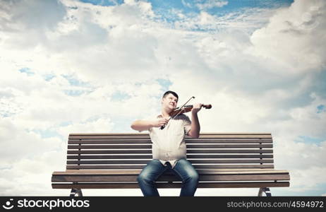 Fat man sitting on bench and playing violin. Fat man