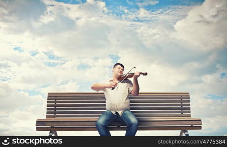 Fat man sitting on bench and playing violin. Fat man