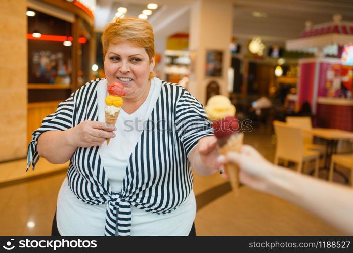 Fat woman buying two ice creams in fastfood mall restaurant. Overweight female person with ice-cream, obesity problem. Fat woman buying ice creams, fastfood restaurant