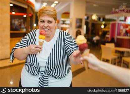 Fat woman buying two ice creams in fastfood mall restaurant. Overweight female person with ice-cream, obesity problem. Fat woman buying ice creams, fastfood restaurant