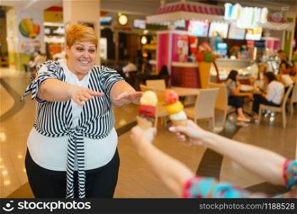 Fat woman buying two ice creams in fastfood mall restaurant. Overweight female person with ice-cream, obesity problem. Fat woman buying ice creams, fastfood restaurant