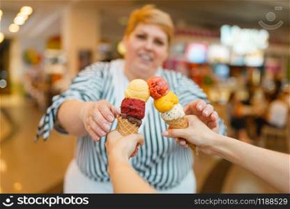 Fat woman buying two ice creams in fastfood mall restaurant. Overweight female person with ice-cream, obesity problem