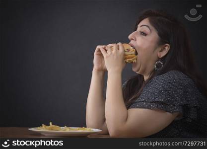 Fat woman eating a hamburger