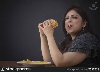 Fat woman eating a hamburger