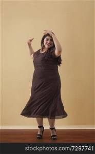 Fat woman in a long brown dress dancing on high heels