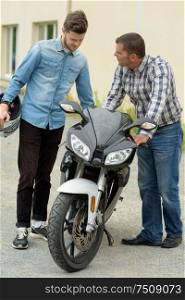 father advising son before using his motorcycle