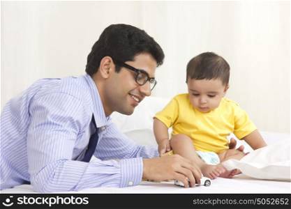 Father and baby playing with toy car