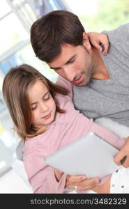 Father and child using electronic tablet at home