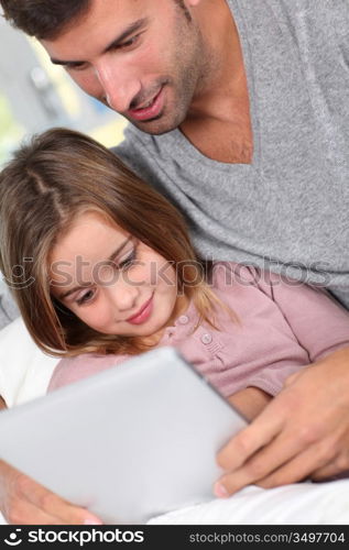 Father and child using electronic tablet at home