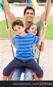Father and children enjoying swing ride on a sunny day