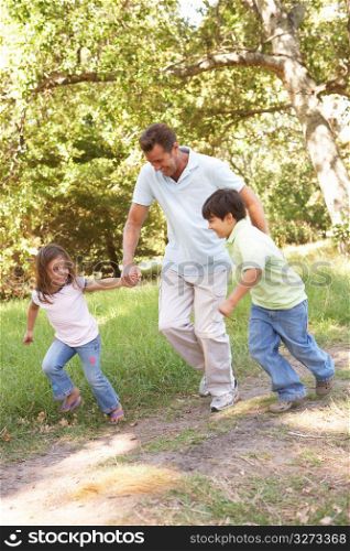 Father And Children Enjoying Walk In Park