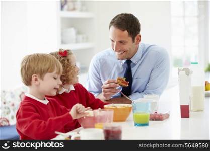 Father And Children Having Breakfast In Kitchen Together
