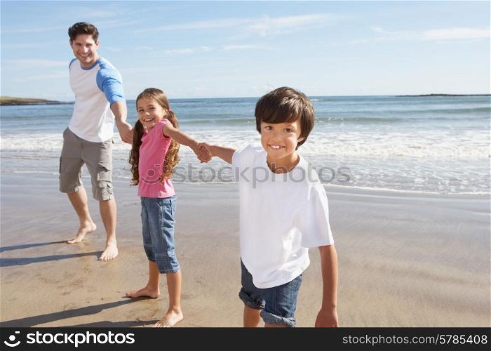 Father And Children Having Fun On Beach Holiday