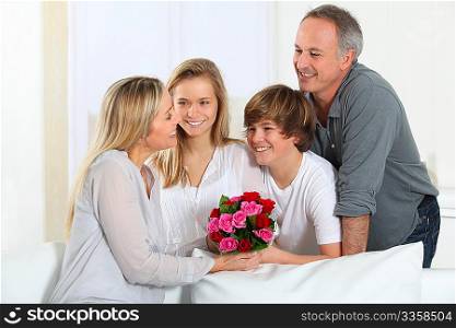 Father and children offering bunch of flowers on mother&acute;s day