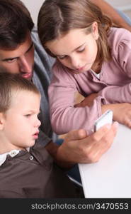 Father and children playing with smartphone