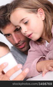 Father and children playing with smartphone