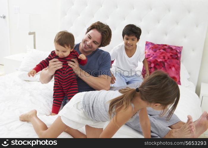 Father And Children Relaxing In Bed Together