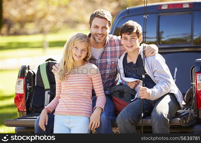 Father And Children Sitting In Truck On Camping Holiday