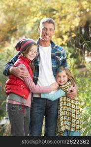 Father And Children Standing Outdoors On Wooden Walkway In Autumn Landscape