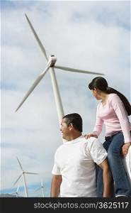 Father and daughter (7-9) near wind turbines at wind farm