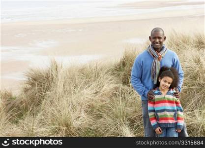 Father And Daughter Amongst Dunes On Winter Beach